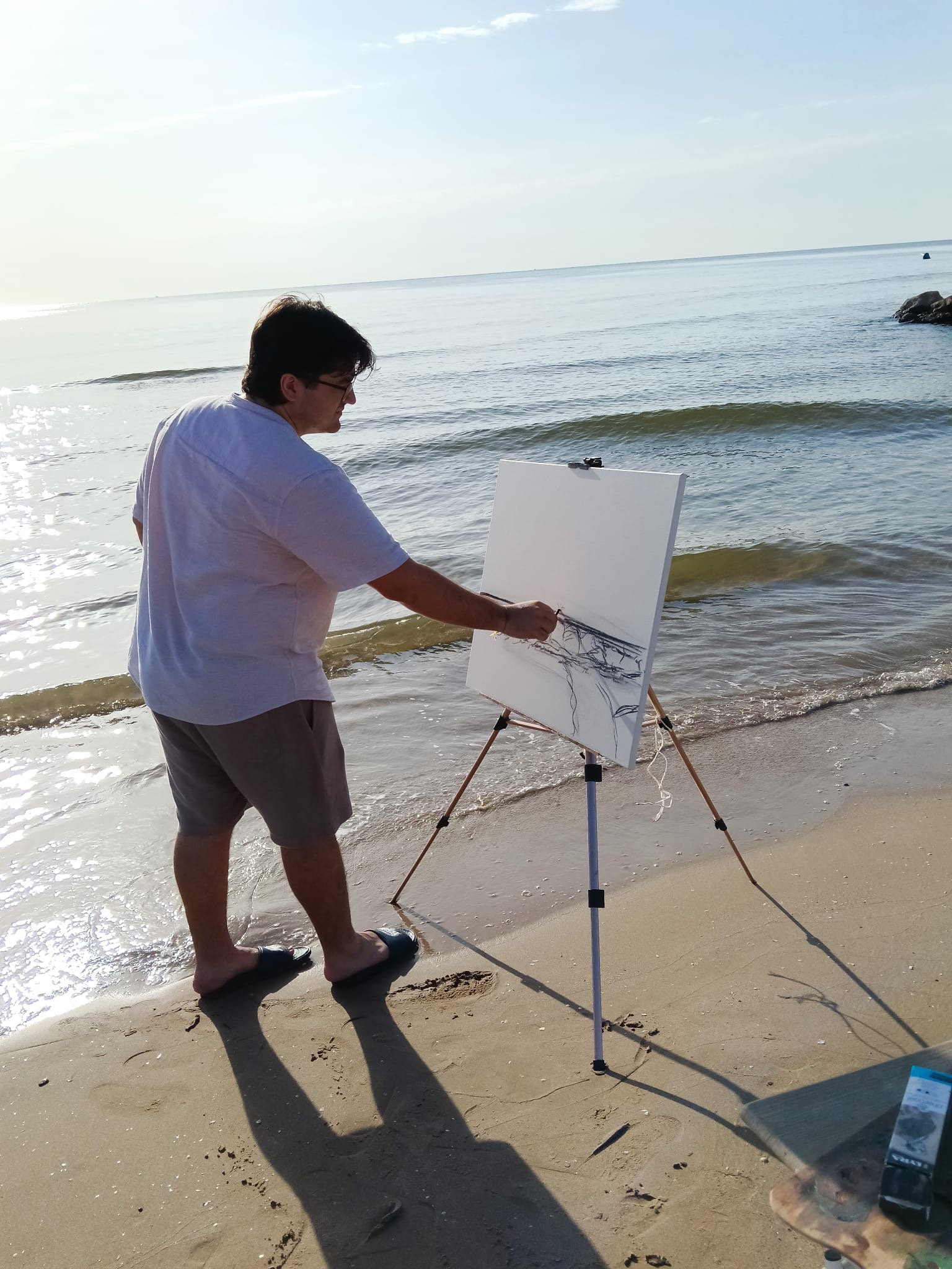 El artista dibujando junto al mar en la Patacona